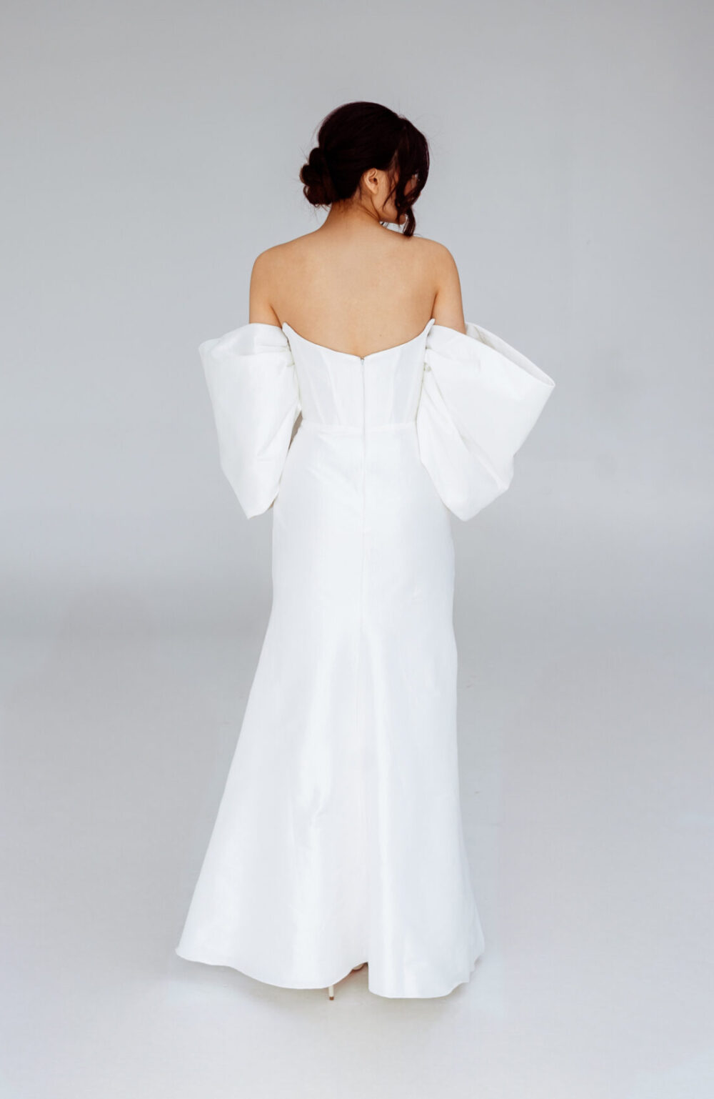 Elegant strapless mermaid wedding dress with detachable sleeves and high slit, perfect for modern brides