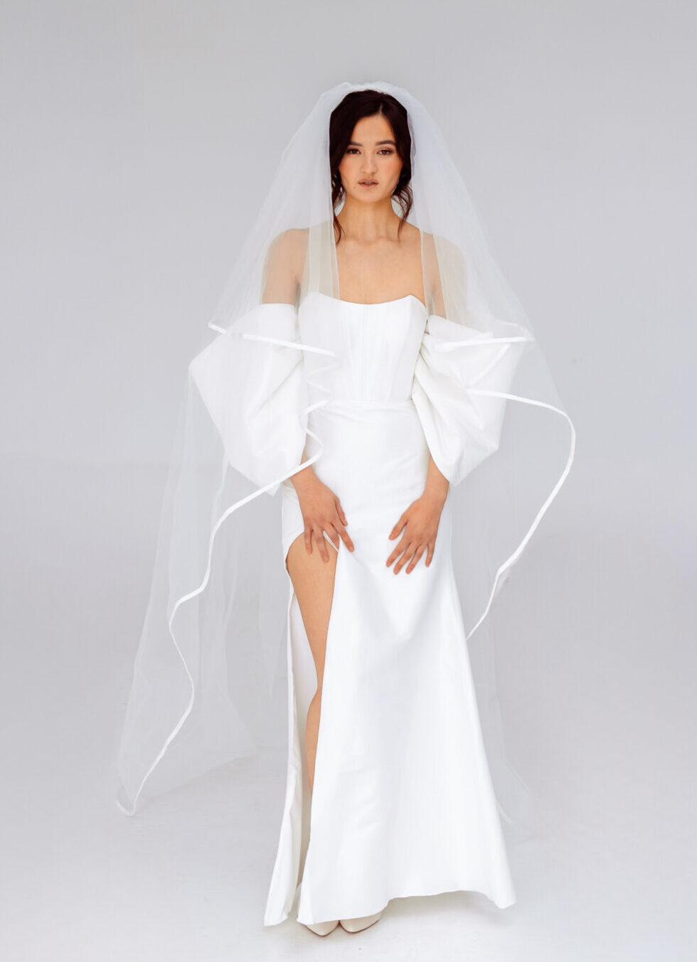 Elegant strapless mermaid wedding dress with detachable sleeves and high slit, perfect for modern brides