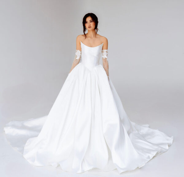 scooped neck ballgown wedding dress by Guillermo Pharis Bridal, featuring a structured Basque waist, detachable lace sleeves, and a flowing chapel train